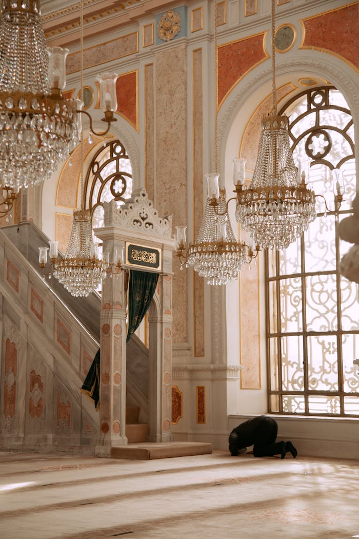 A person is praying inside a beautifully decorated mosque in Istanbul, Turkey.